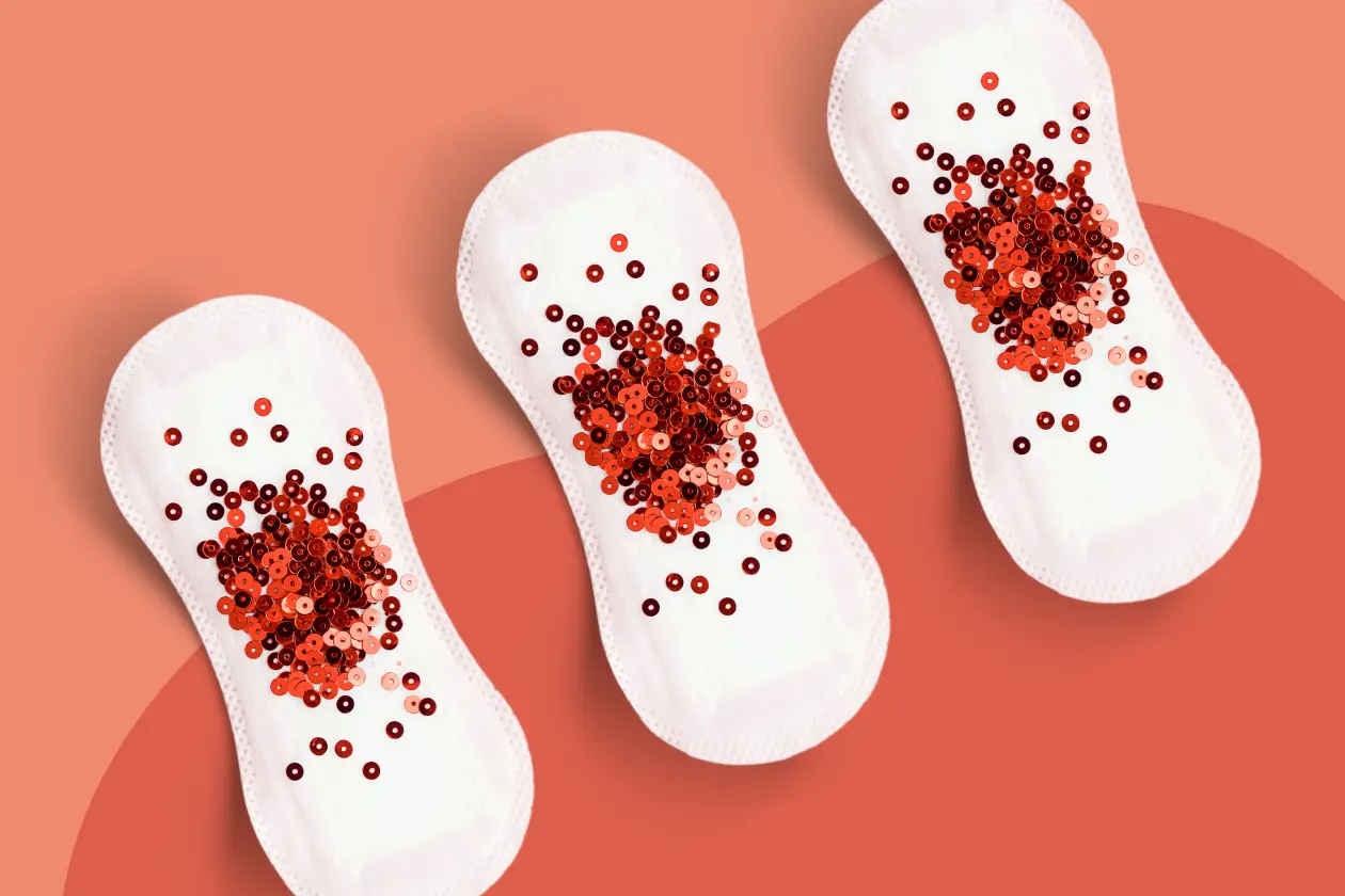 Three sanitary pads on a coral background with red sequins representing heavy menstrual flow and abnormal uterine bleeding during perimenopause.