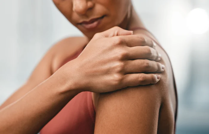 Femme tenant son épaule, un signe fréquent de douleurs articulaires en périménopause