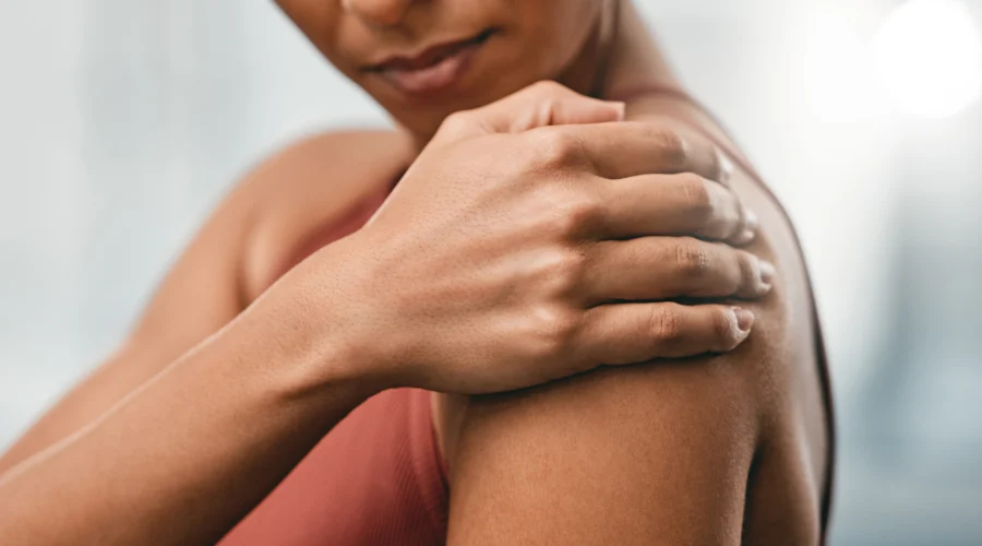 Femme tenant son épaule, un signe fréquent de douleurs articulaires en périménopause