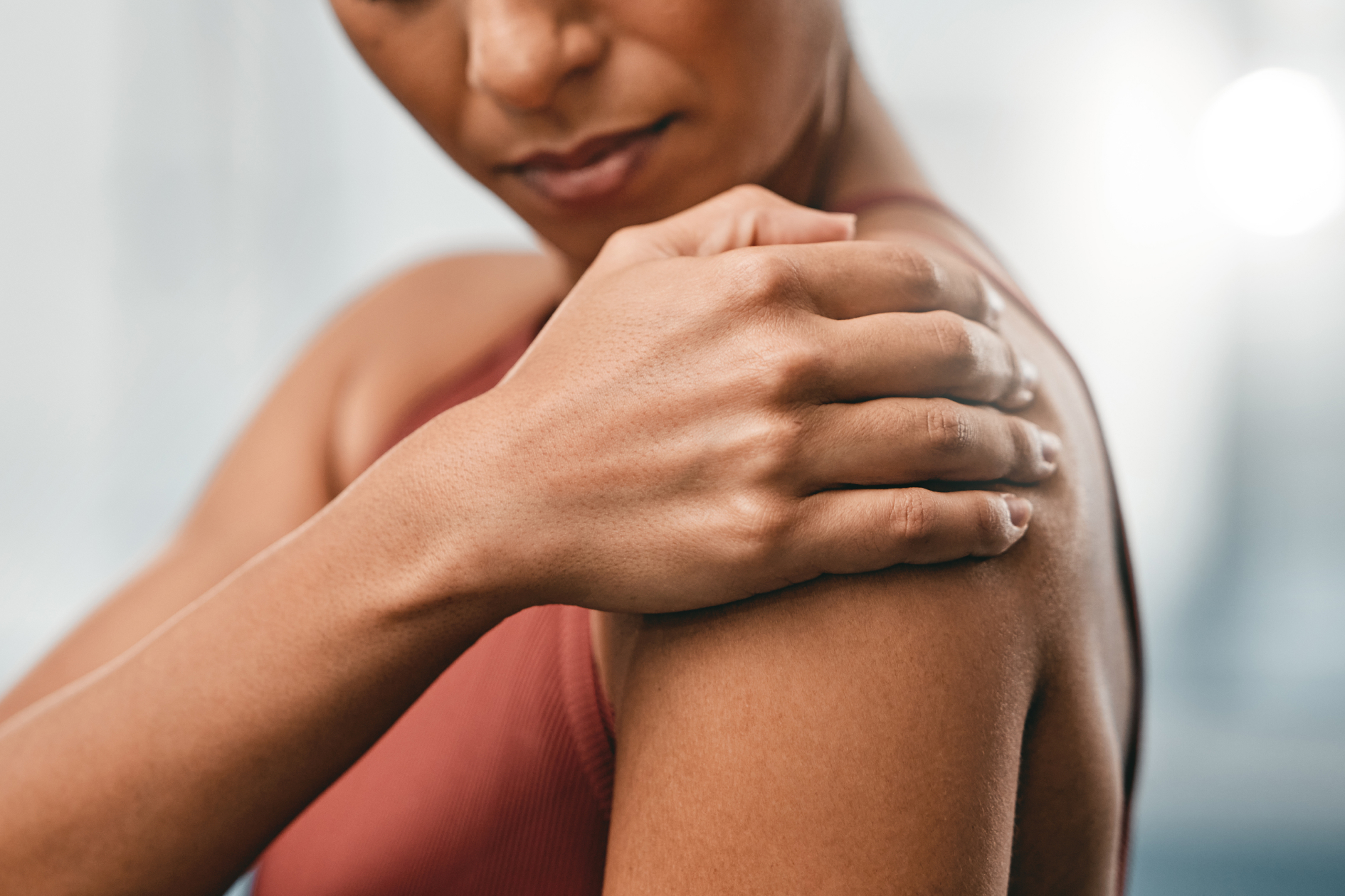 Femme tenant son épaule, un signe fréquent de douleurs articulaires en périménopause